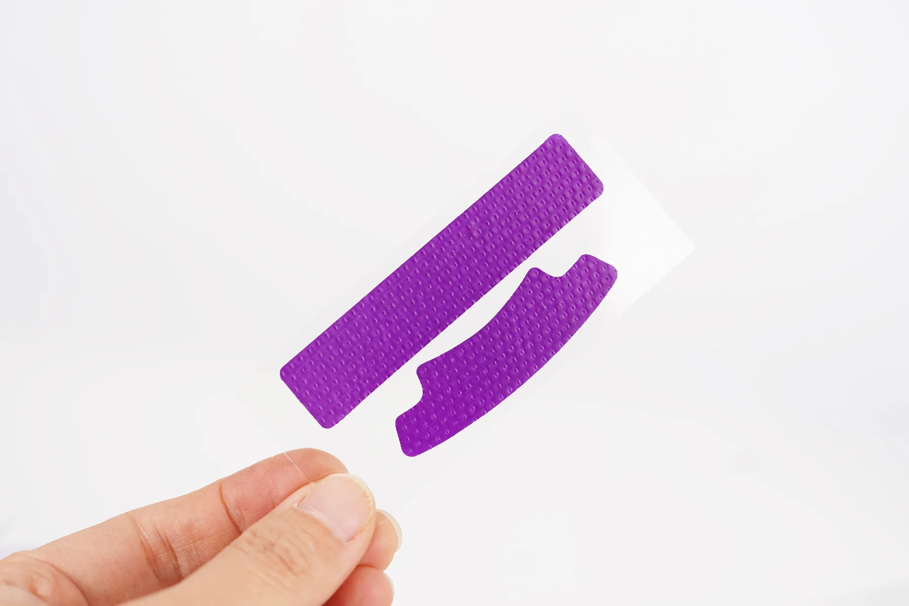 Purple teeth whitening strips held by hand